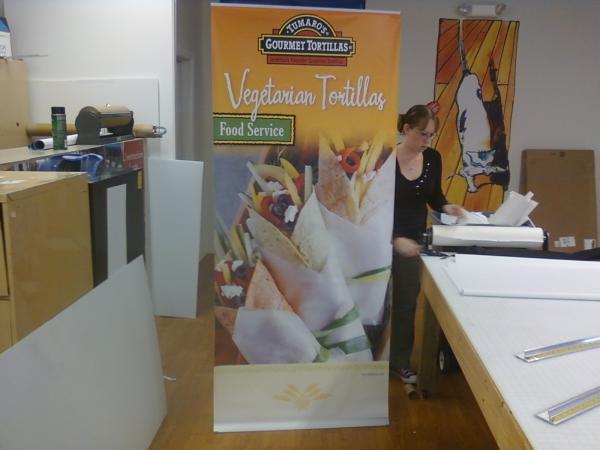 1 of the 6 36"x84" trade show displays for Blue Marble Brands next to the shop's secretary Brandy for size relation.
